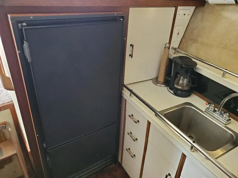 Slide: The Image of 1983 Carver 3207 AFT Cabin Motor Yacht kitchen with sink, fridge, and coffee maker. - 15