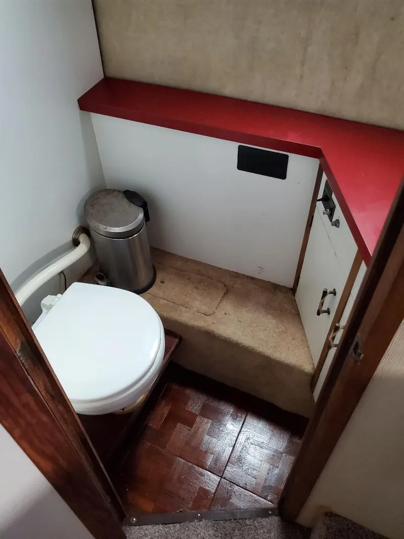 Slide: The Image of 1983 Carver 3207 Aft Cabin Motor Yacht bathroom with red countertop and toilet. - 3