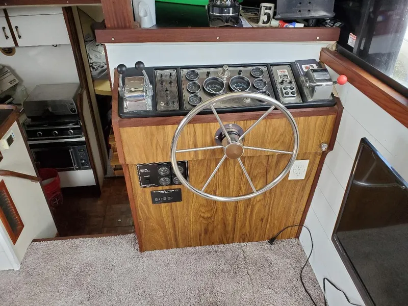 Slide: The Image of 1983 Carver 3207 AFT Cabin Motor Yacht helm with steering wheel and control panel. - 8