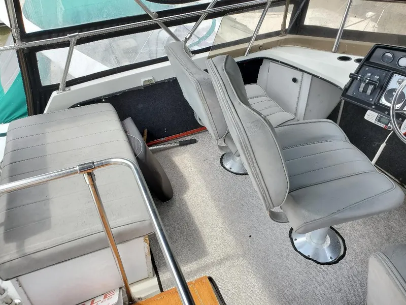 Slide: The Image of 1983 Carver 3207 AFT Cabin Motor Yacht interior with gray seating and control panel. - 14
