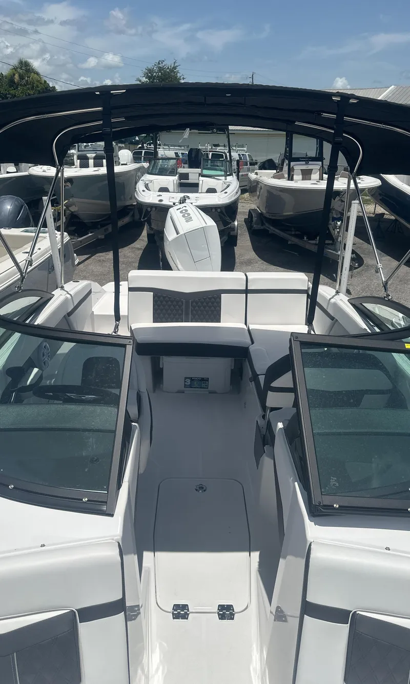 Slide: The Image of 2025 Monterey M-205 boat with sleek design and spacious seating, docked under clear skies. - 10