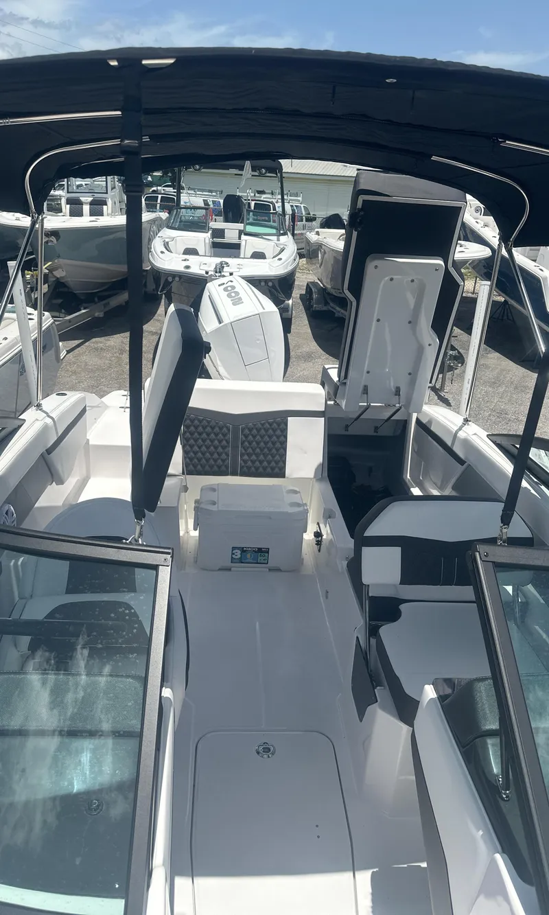 Slide: The Image of 2025 Monterey M-205 boat interior with seating and open deck, displayed at a marina. - 12