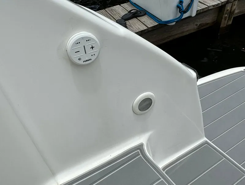 Slide: The Image of 2003 Regal Commodore 3860 boat deck with audio controls and dock background. - 10