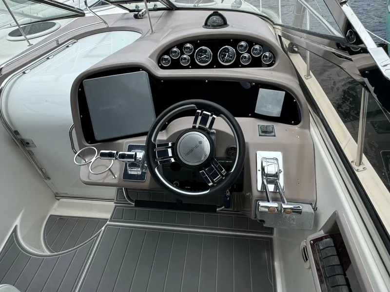 Slide: The Image of 2003 Regal Commodore 3860 boat dashboard with steering wheel and control panel. - 14