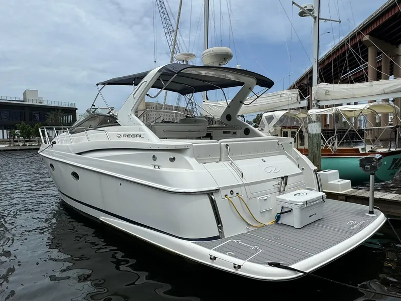 Slide: The Image of 2003 Regal Commodore 3860 yacht docked at marina, sleek white design. - 2