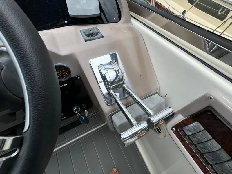 Slide: The Image of 2003 Regal Commodore 3860 boat controls with steering wheel and throttle levers. - 25