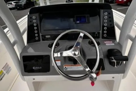 Slide: The Image of 2022 Robalo R230 Center Console boat dashboard with steering wheel and controls. - 18
