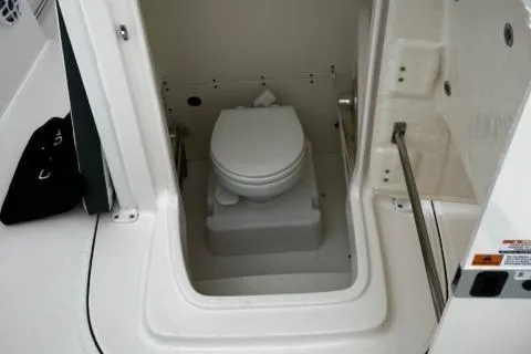 Slide: The Image of 2022 Robalo R230 Center Console boat interior with compact marine toilet. - 24