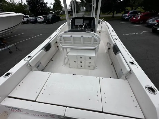 Slide: The Image of 2022 Robalo R230 Center Console boat interior with seating and console in a parking lot. - 5
