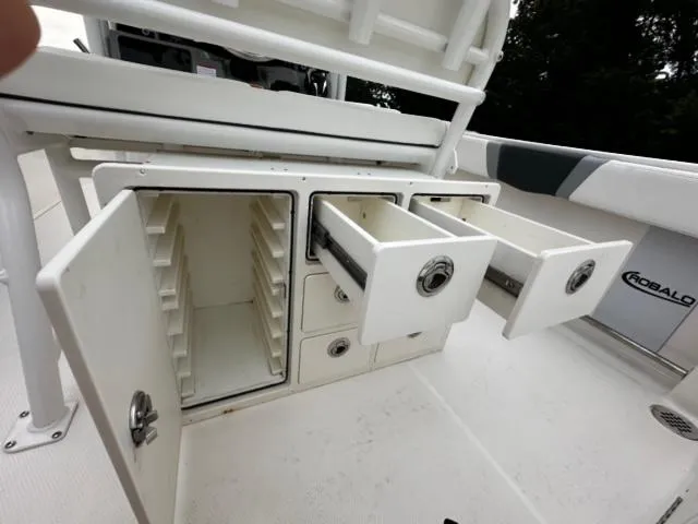 Slide: The Image of 2022 Robalo R230 Center Console storage compartments with open drawers and cabinets. - 8