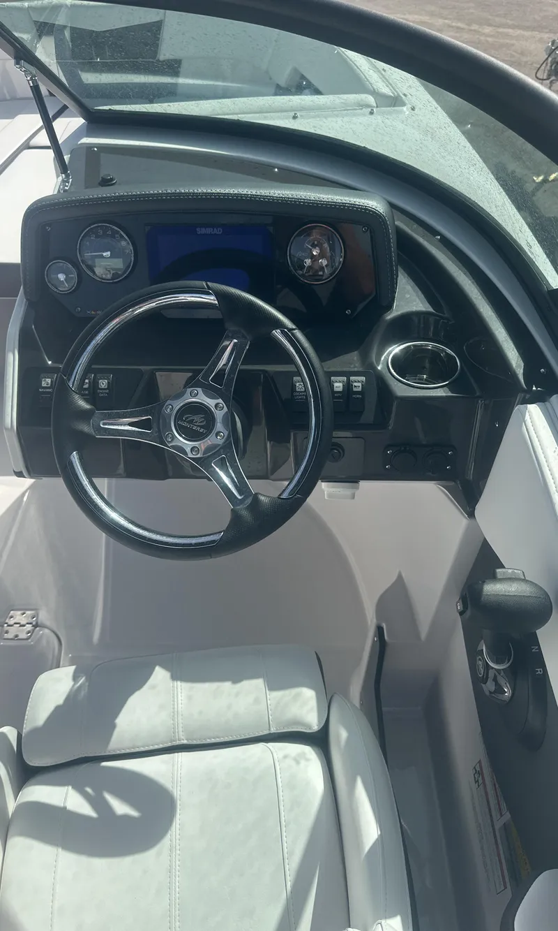 Slide: The Image of 2025 Monterey M-225 boat interior with open storage compartment and sleek seating design. - 16