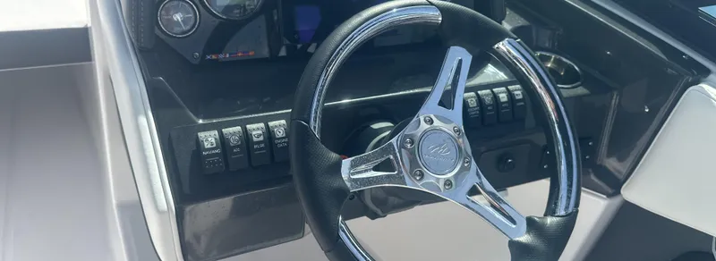 Slide: The Image of 2025 Monterey M-225 boat interior with control panel and storage compartment. - 19