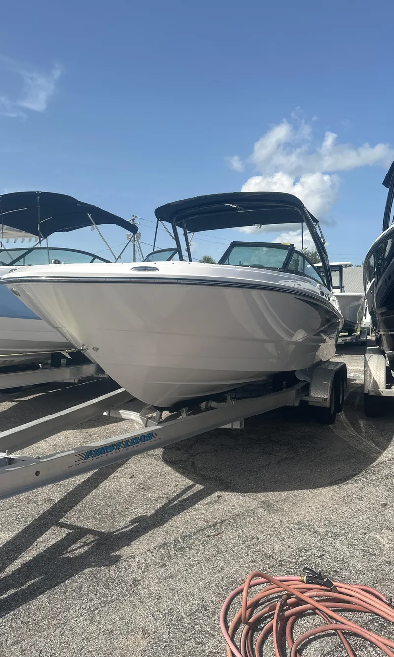Slide: The Image of 2025 Monterey M-225 boat with sleek design, parked under a clear blue sky. - 2