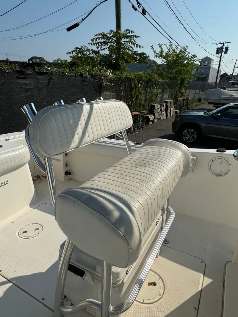 Slide: The Image of 2005 Sea Hunt Triton 232 boat interior with white cushioned seating. - 10