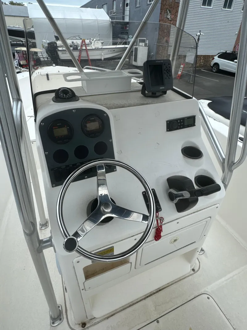 Slide: The Image of 2005 Sea Hunt Triton 232 boat console with steering wheel and gauges. - 22