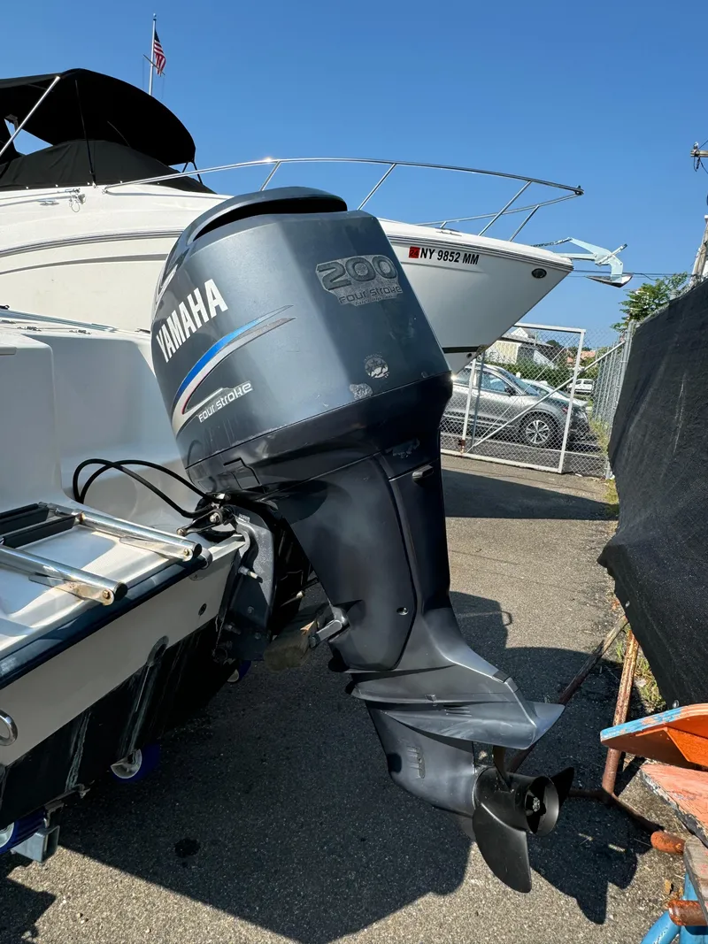 Slide: The Image of 2005 Sea Hunt Triton 232 with Yamaha 200 outboard motor in a marina setting. - 4