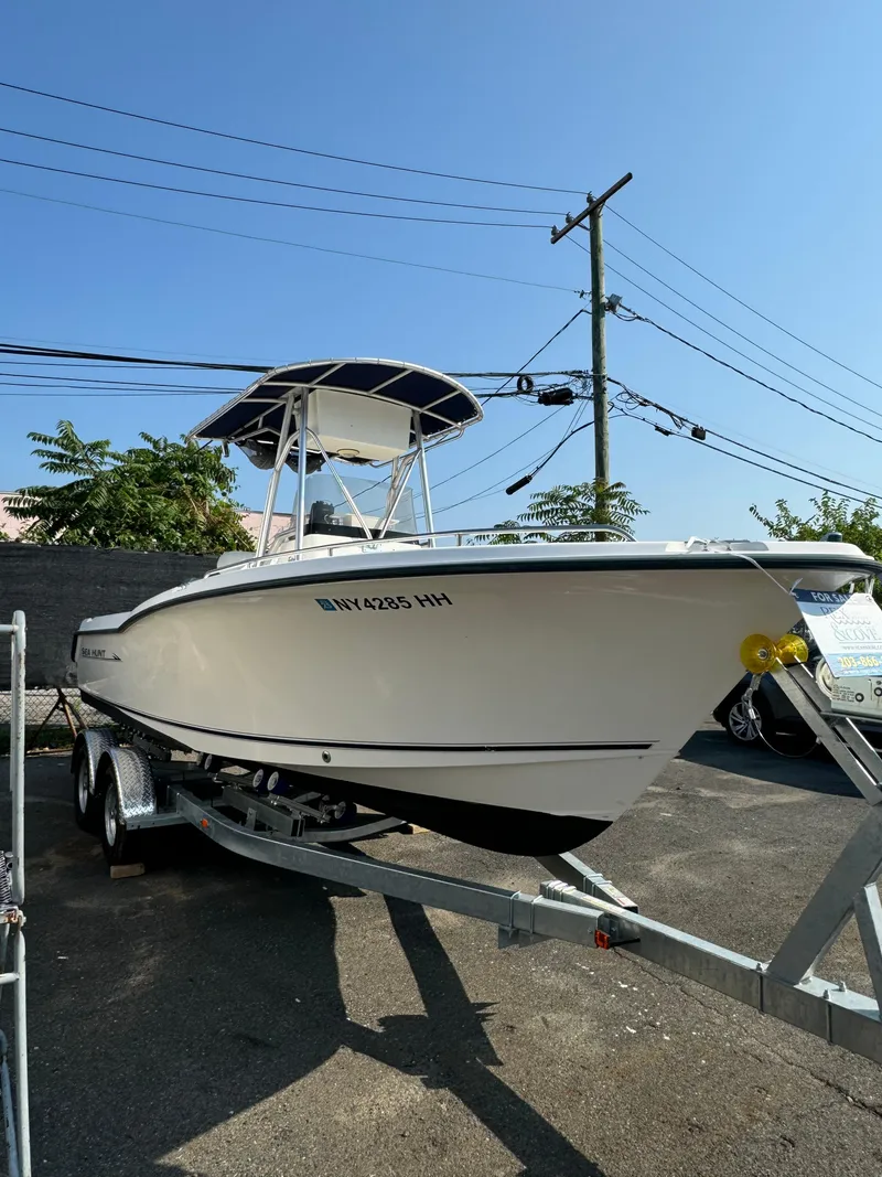 Slide: The Image of 2005 Sea Hunt Triton 232 boat on trailer, parked outdoors under clear sky. - 7