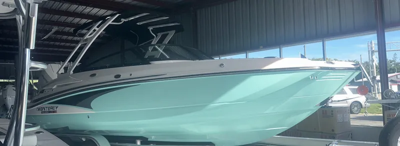 The Image of 2025 Monterey M45 boat in a storage facility, featuring sleek design and mint green hull. - 0