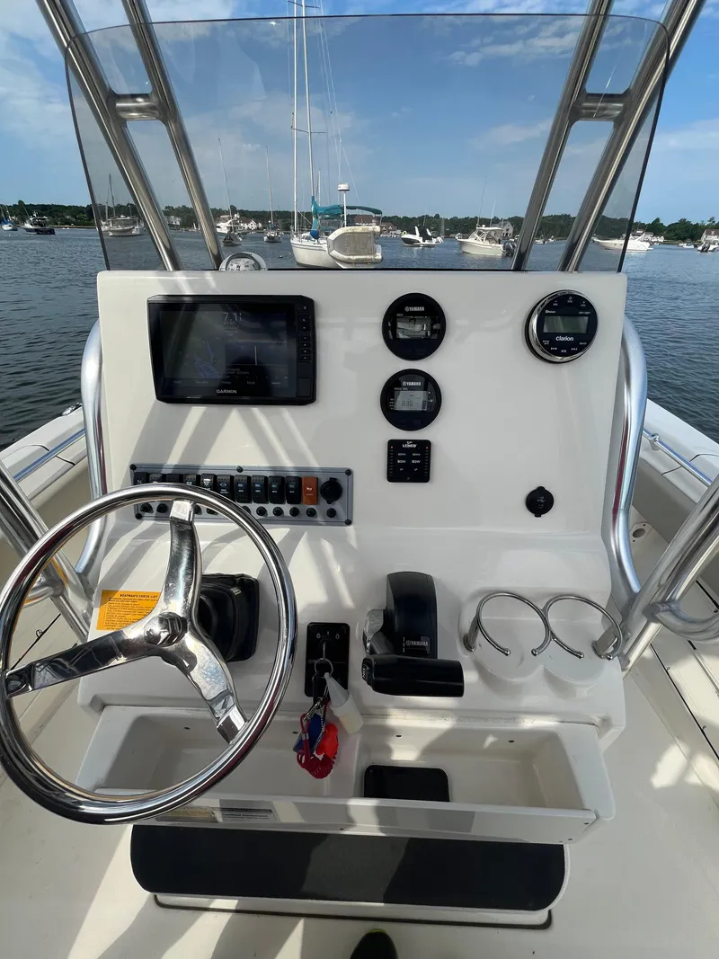 Slide: The Image of 2021 Key West 219 FS boat console with steering wheel, gauges, and navigation system. - 10