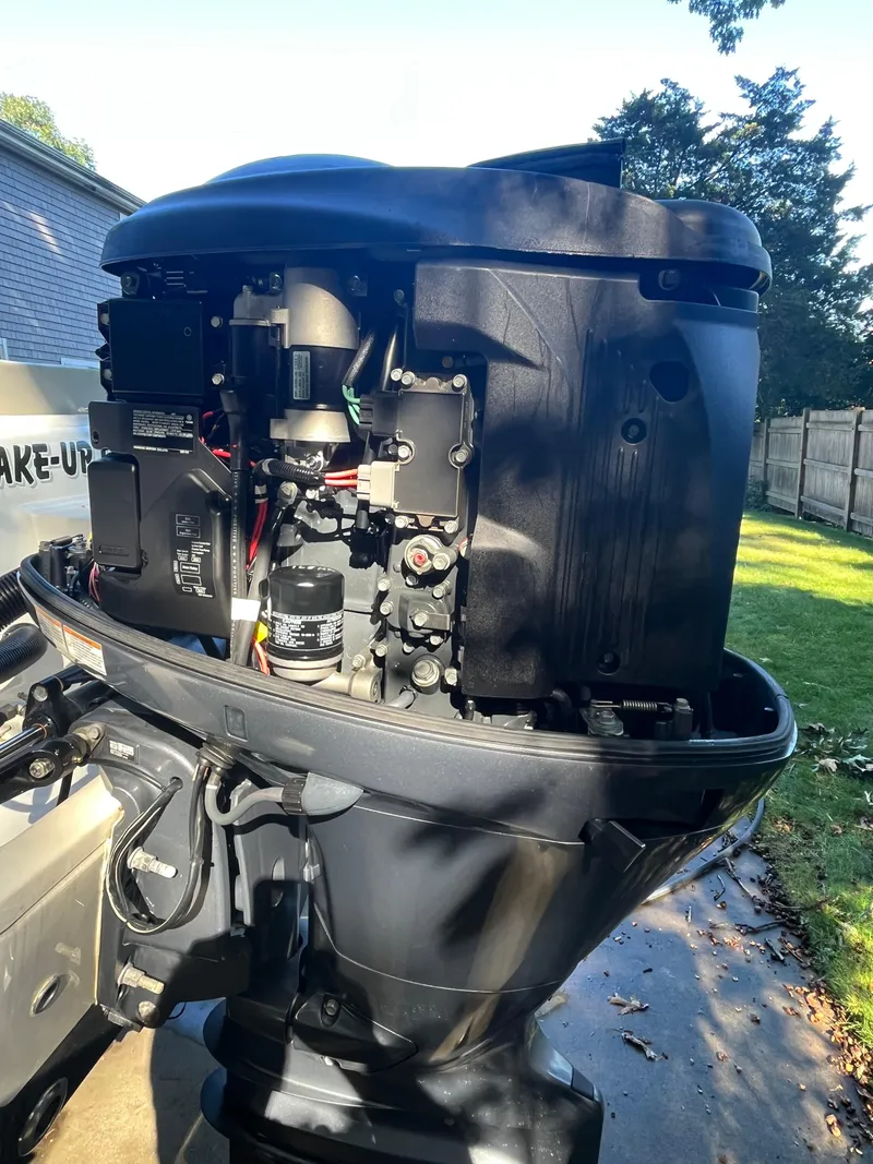 Slide: The Image of 2021 Key West 219 FS boat engine, detailed view in a sunny backyard. - 21