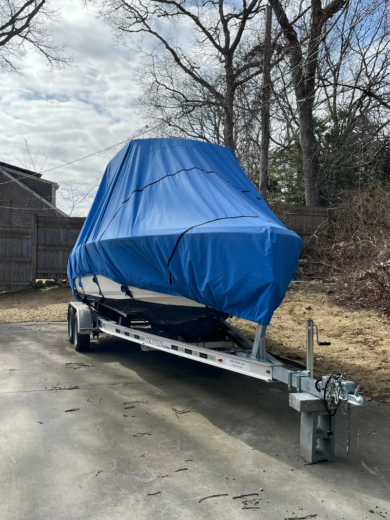 Slide: The Image of 2021 Key West 219 FS boat covered in blue tarp on trailer. - 24