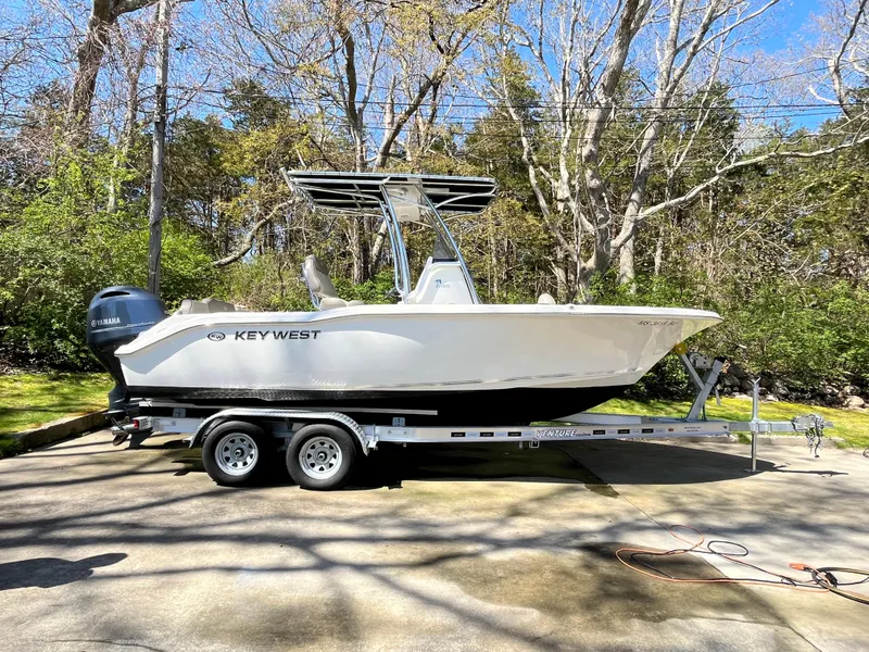 Slide: The Image of 2021 Key West 219 FS boat on trailer in wooded driveway setting. - 5
