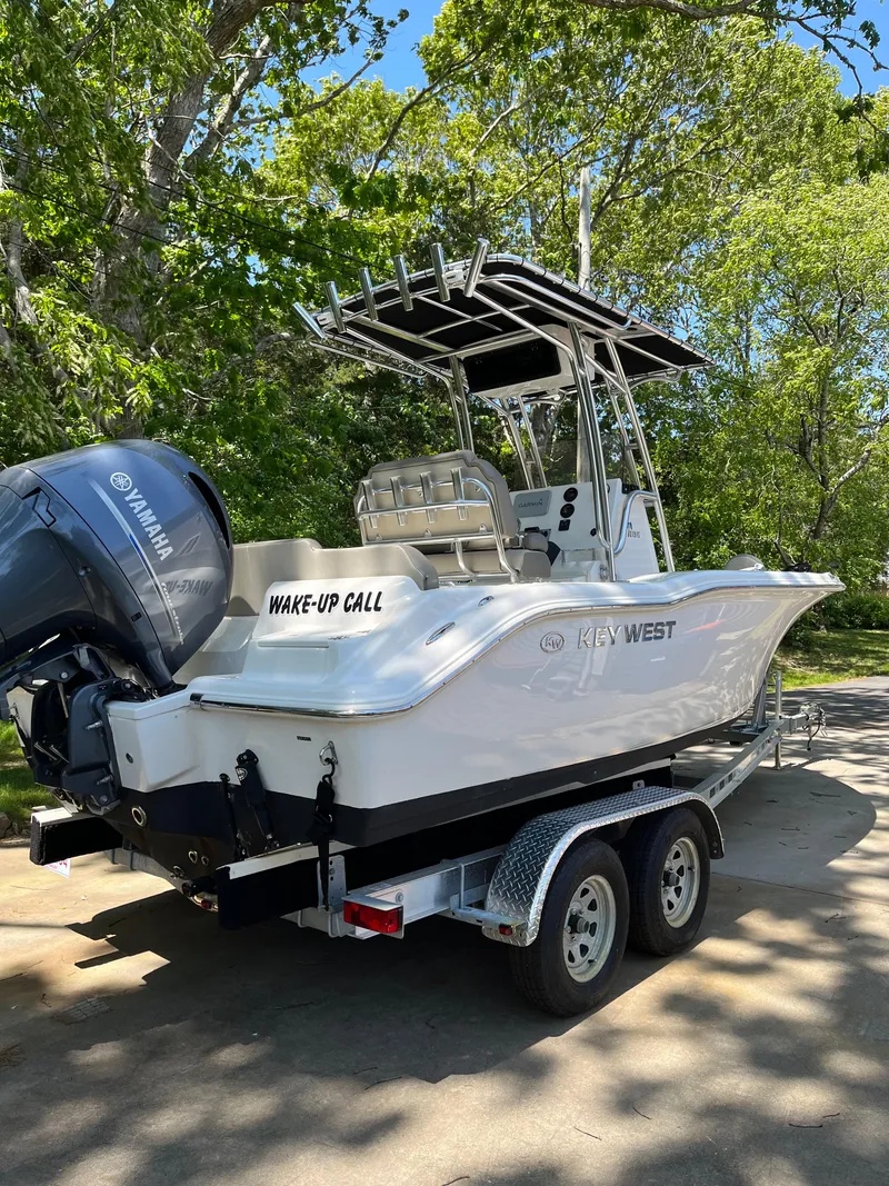Slide: The Image of 2021 Key West 219 FS boat on trailer with Yamaha engine, parked outdoors. - 8