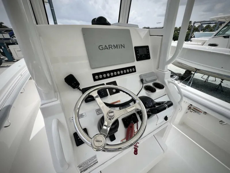 Slide: The Image of 2020 Regulator 23 boat helm with Garmin navigation system and steering wheel. - 15