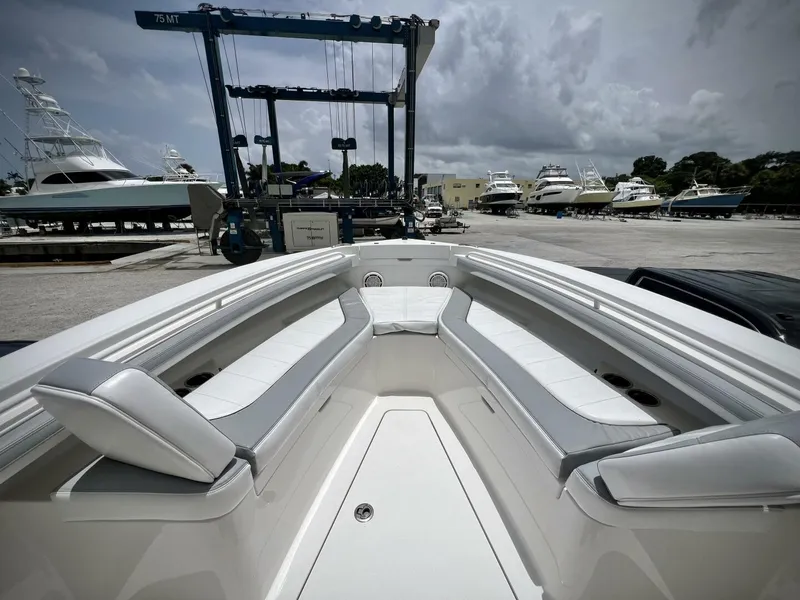 Slide: The Image of 2020 Regulator 23 boat interior with seating, docked at marina under cloudy sky. - 21