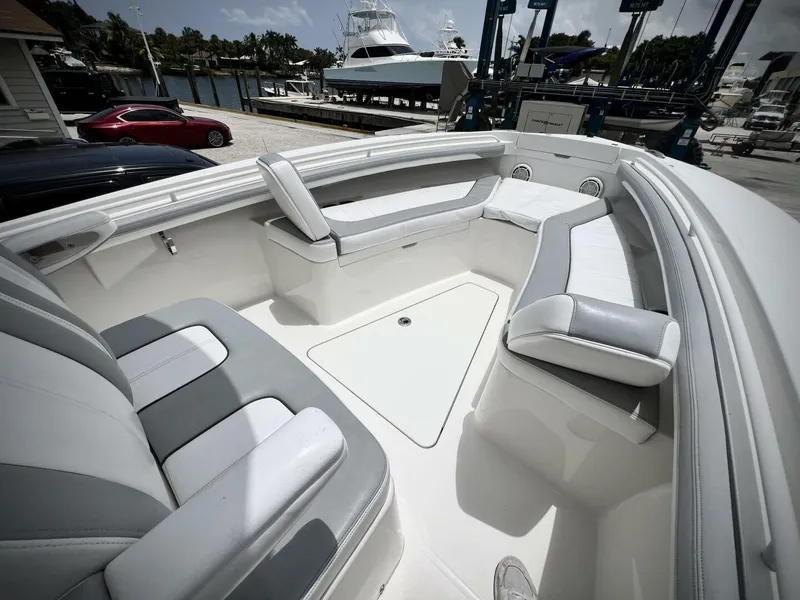 Slide: The Image of 2020 Regulator 23 boat interior with cushioned seating, docked at marina. - 25