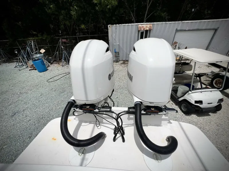 Slide: The Image of Twin outboard motors on a 2020 Regulator 23 boat, parked in a gravel lot. - 33