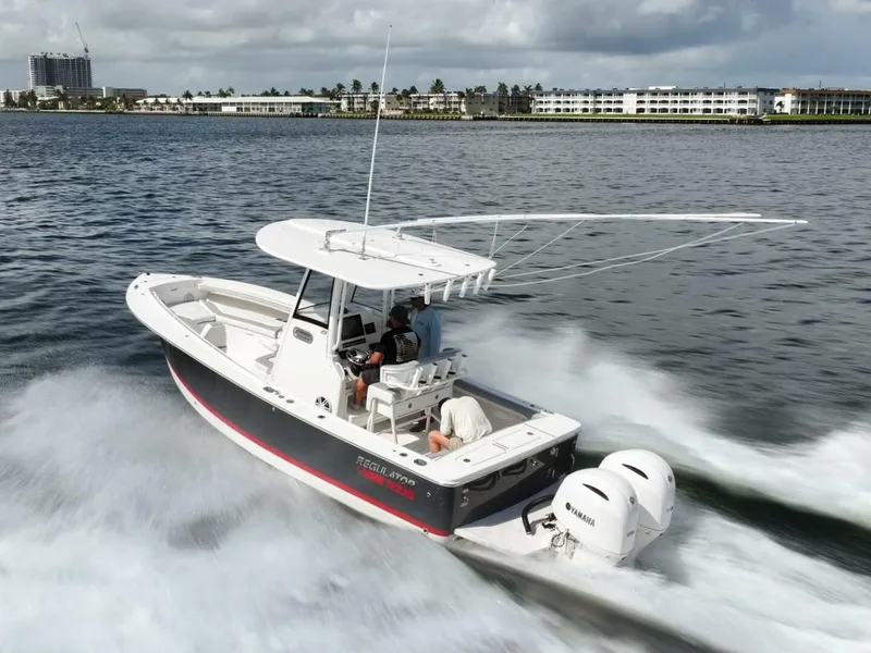 Slide: The Image of 2020 Regulator 23 boat cruising on water with twin Yamaha engines. - 4