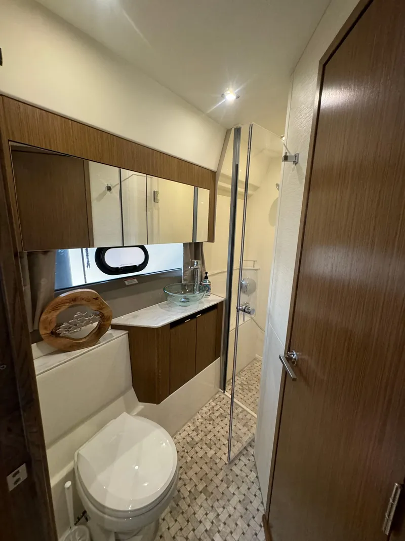 Slide: The Image of Luxurious bathroom in 2017 Sea Ray Sundancer yacht with modern fixtures and elegant wood finishes. - 10