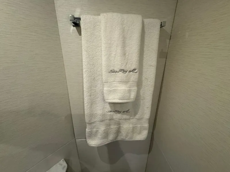 Slide: The Image of White towels with "Sea Ray" embroidery hanging in a 2017 Sundancer yacht bathroom. - 17