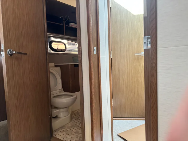 Slide: The Image of Interior of 2017 Sea Ray Sundancer yacht showing bathroom with wooden doors and modern fixtures. - 2