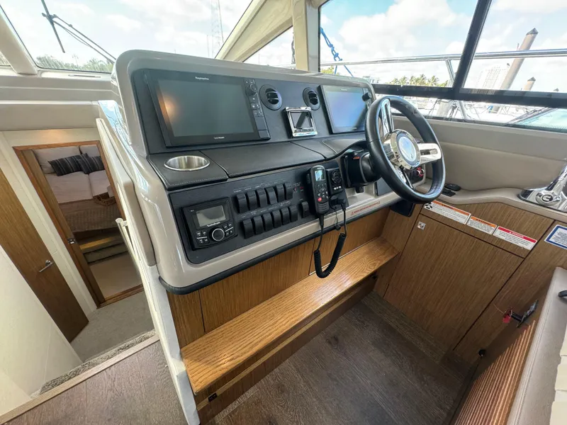 Slide: The Image of 2017 Sea Ray Sundancer helm with modern navigation equipment and wooden interior finish. - 40