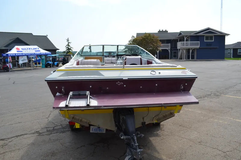 Slide: The Image of 1986 Four Winns Open Bow boat on trailer in parking lot. - 1
