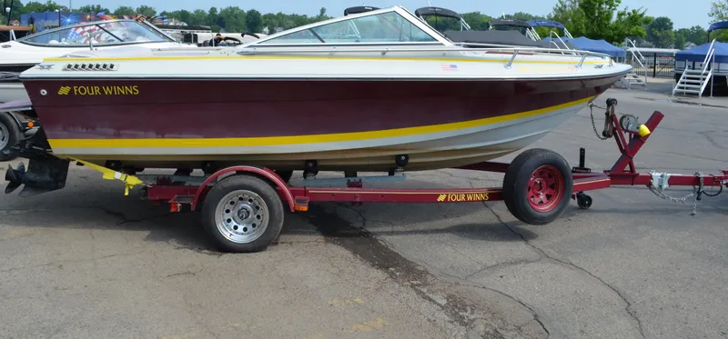 Slide: The Image of 1986 Four Winns Open Bow boat on trailer, maroon and yellow design. - 10