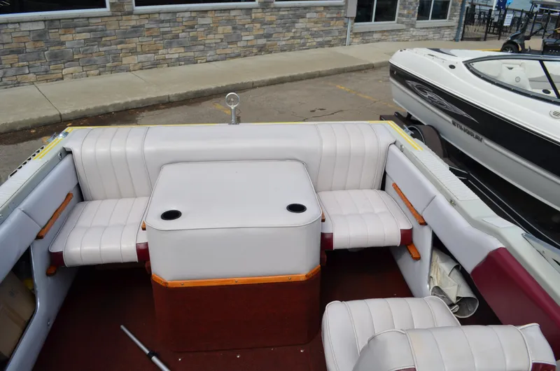 Slide: The Image of 1986 Four Winns Open Bow boat interior with white seating and table. - 5