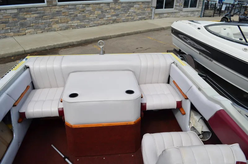 Slide: The Image of 1986 Four Winns Open Bow boat interior with white seating and central table. - 6