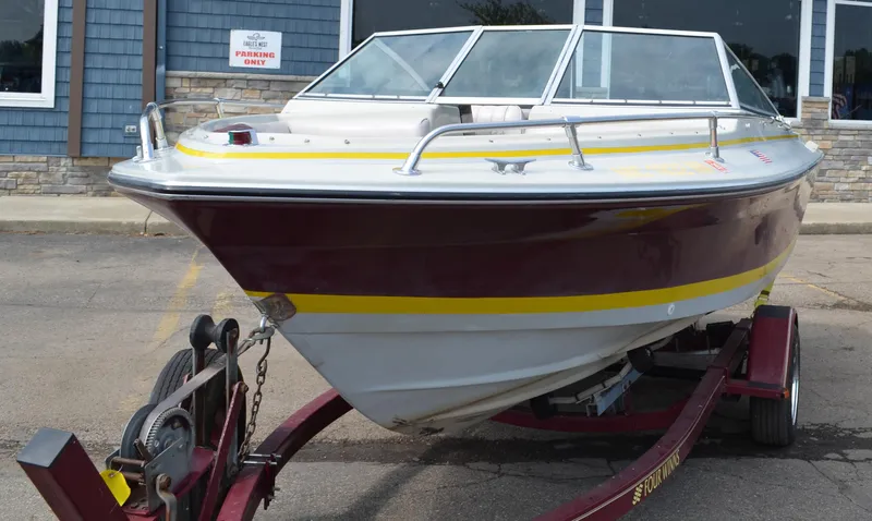 Slide: The Image of 1986 Four Winns Open Bow boat on trailer, maroon and yellow accents. - 7