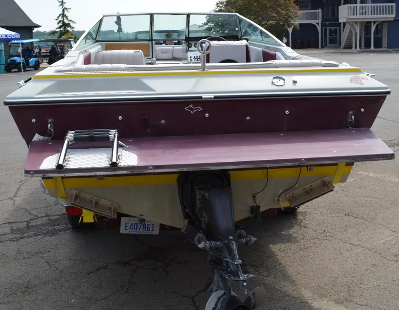 Slide: The Image of 1986 Four Winns Open Bow boat, rear view with ladder and outboard motor. - 8