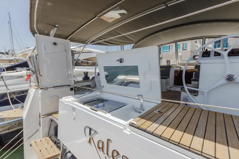 Slide: The Image of 2022 Bavaria C50 yacht with outdoor kitchen and helm, docked at marina. - 15