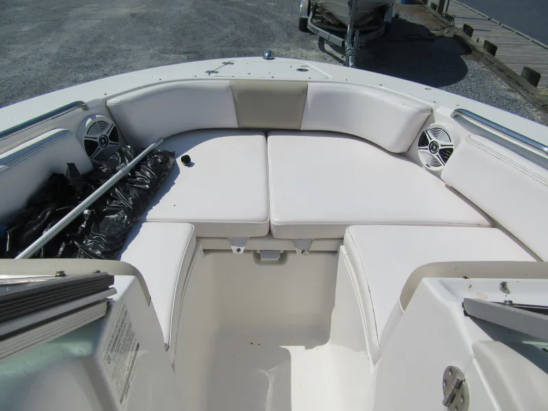 Slide: The Image of 2019 Robalo R207 Dual Console boat with white cushioned seating and speakers. - 10