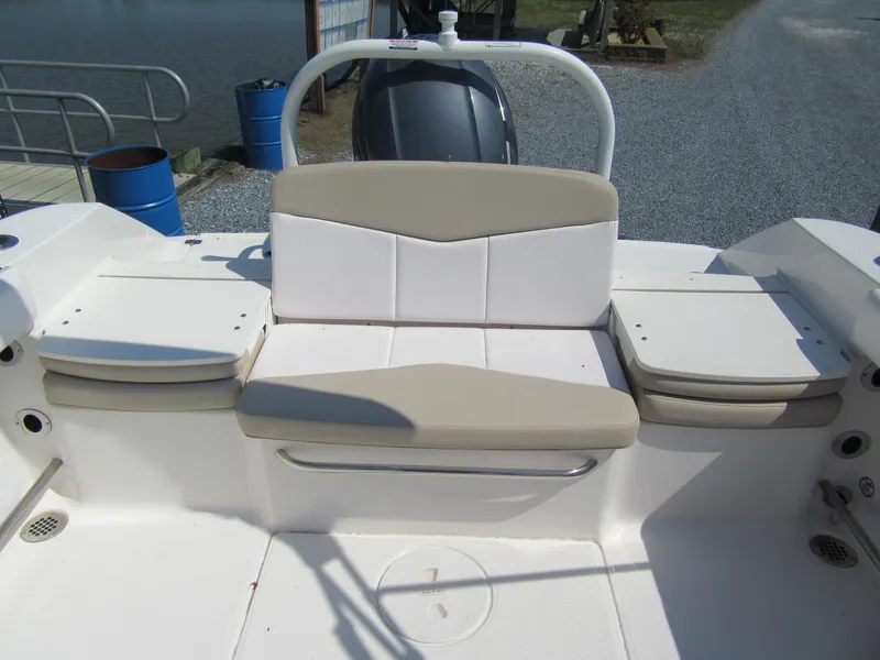 Slide: The Image of 2019 Robalo R207 Dual Console boat seating area with cushioned bench and storage compartments. - 4