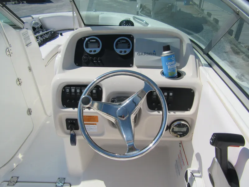 Slide: The Image of 2019 Robalo R207 Dual Console boat dashboard with steering wheel and Garmin display. - 7