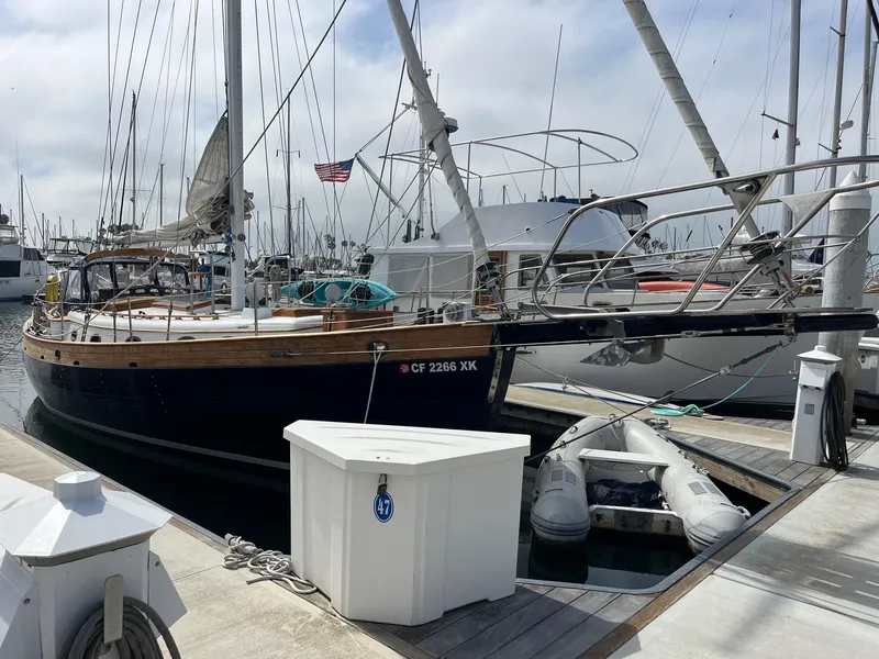 Slide: The Image of 1976 Hans Christian 38T sailboat docked at marina with dinghy nearby. - 2