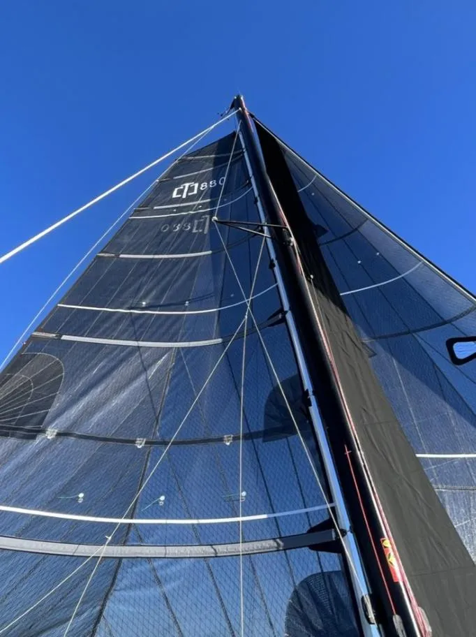 Slide: The Image of Corsair 880 Standard 2024 sailboat with black sails against blue sky. - 3