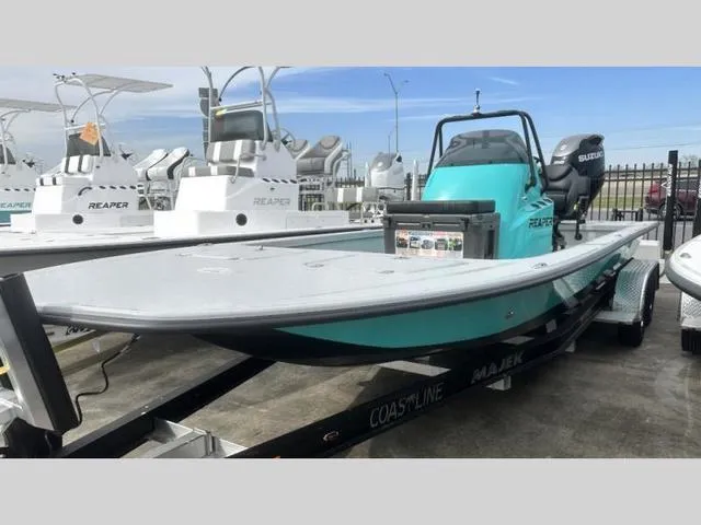 Slide: The Image of 2024 Majek Boats 24 REAPER in turquoise, displayed on a trailer at a dealership. - 4