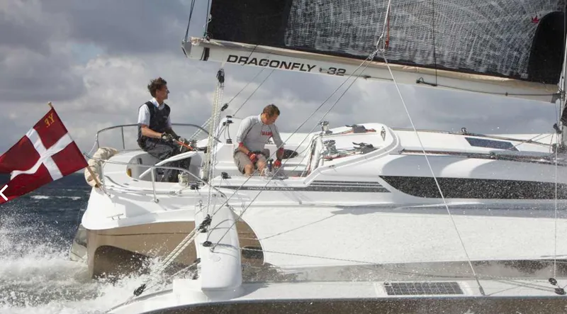 The Image of Sailing on Dragonfly 32 trimaran, two people navigate choppy waters under cloudy skies. - 0